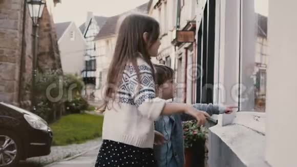 可爱的男孩和女孩在玩具商店挑选礼物两个白人孩子站在橱窗里购物哈廷根德国4K视频的预览图