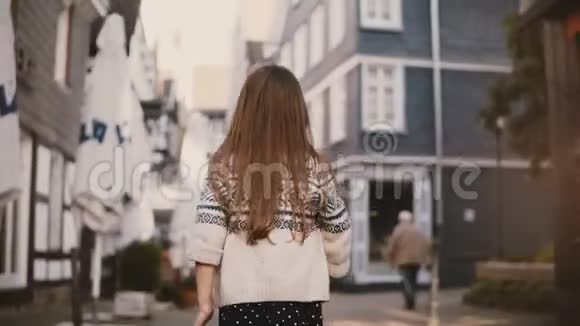 镜头跟随小女孩在老城散步后景女孩子长发在古老的街道上游荡4K视频的预览图
