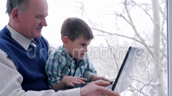 养老金领取者支付在线计算机技术孙子与爷爷手提手提电脑进入房间窗口视频的预览图