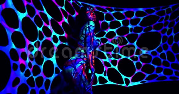 一位年轻女子在紫外线晚会上跳舞她的身体艺术色彩鲜艳视频的预览图