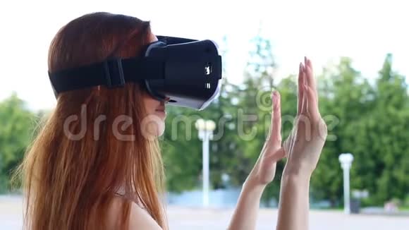 户外长棕色头发的女孩玩虚拟现实眼镜视频的预览图