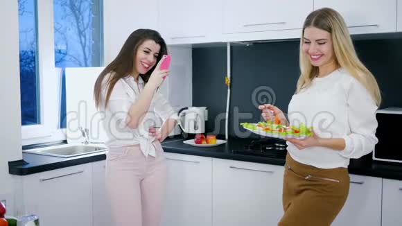 健康的饮食漂亮的女友在厨房用沙拉拍照视频的预览图