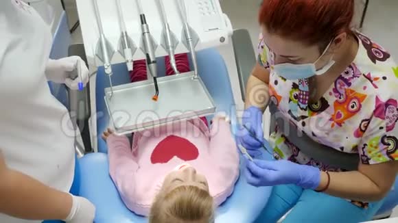 在医院里小女孩躺在牙科椅上用新设备旁边的工具和牙齿矫正器一起治疗视频的预览图