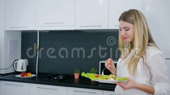 健康的生活方式在厨房用手端着生菜的美丽女孩的素食大餐视频的预览图