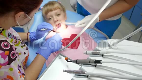 带着牙齿疼痛的患病儿童躺在牙椅上正畸医师手里拿着工具进行检查视频的预览图