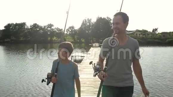 快乐的爸爸和儿子带着鱼竿去池塘钓鱼视频的预览图