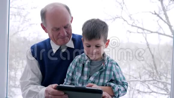 祖父和孙子在家玩电子游戏视频的预览图