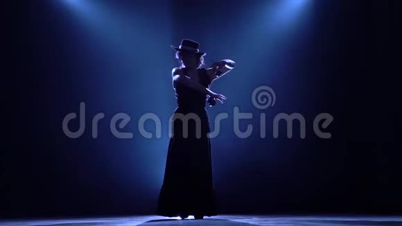 女孩在手里跳舞手里跳舞从后面发光烟雾背景剪影慢动作视频的预览图