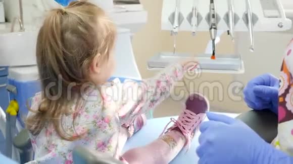 医学和医疗保健双手戴上蓝色橡胶手套带上紫外线灯照在小女孩的手臂上视频的预览图