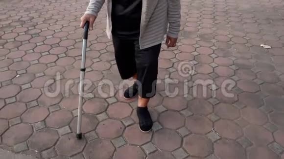 在公园里用手杖把老年妇女的腿伸出来视频的预览图