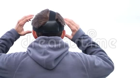 用虚拟现实的VR头戴式眼镜观看天空背景下的人类体验视频的预览图
