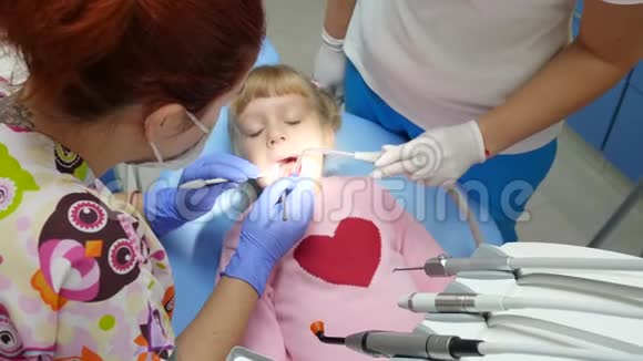 医疗和保健患牙痛的儿童躺在牙科扶手椅上由医生用仪器治疗视频的预览图