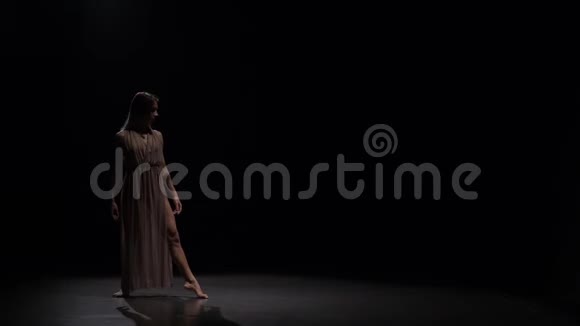 女人在聚光灯的黑色背景下练习当代慢动作视频的预览图