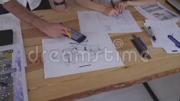 团队合作男人在电话中显示任务女孩在图纸上做笔记视频的预览图