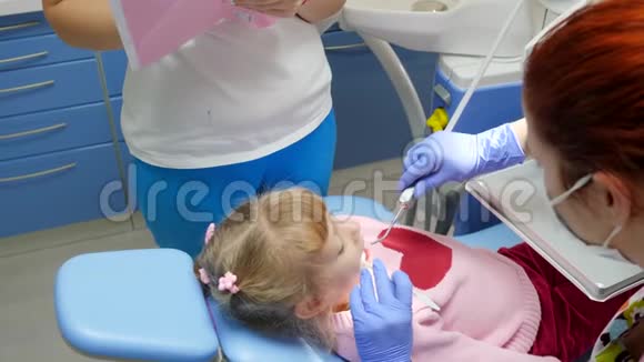 在医院与医生就诊时小病人的开口躺在牙科扶手椅上视频的预览图
