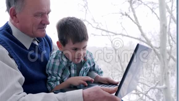 幸福的家庭一起在窗台上的笔记本电脑显示器上看着视频的预览图
