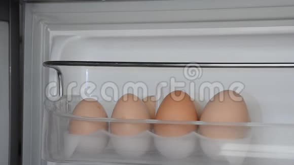 一个人从冰箱的架子上拿了两个鸡蛋视频的预览图