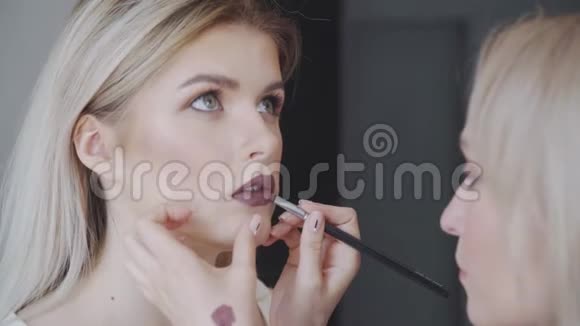 一个漂亮女人的肖像口红涂着深色照在镜子里一个漂亮迷人的女孩画视频的预览图