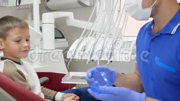医生把牙板放在小病人的下巴上然后对着镜子竖起大拇指视频的预览图
