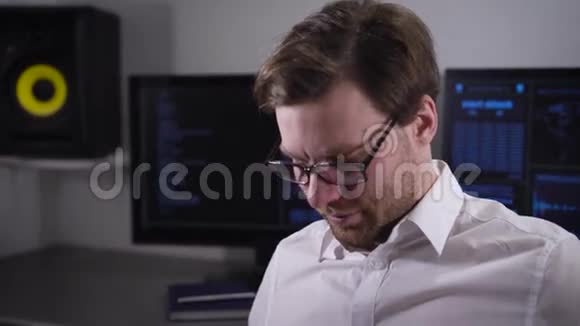 戴眼镜的严肃男子穿着白色衬衫坐在工作区并在笔记本电脑上打印报告这就是视频的预览图