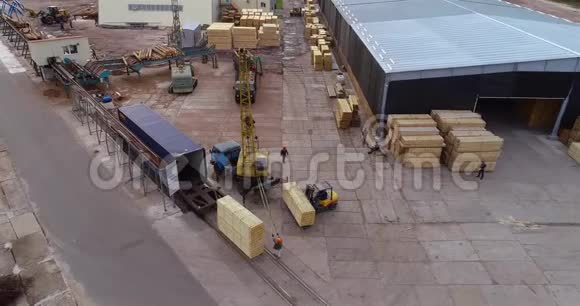 起重机在锯木厂的鸟瞰图上卸下一辆有原木的汽车这是锯木厂从空中的一般景观视频的预览图