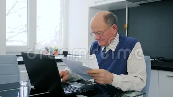 远程商业管理有手提电脑和文件的退休老人视频的预览图