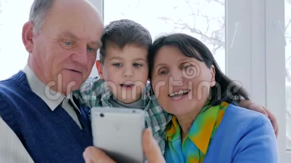 幸福的养老金领取者家庭在室内使用手机上网交流视频的预览图