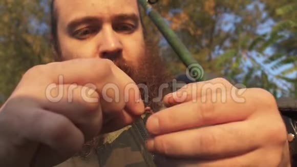 渔夫把一条虫子放在钩子上有胡子的成年钓鱼人的肖像视频的预览图