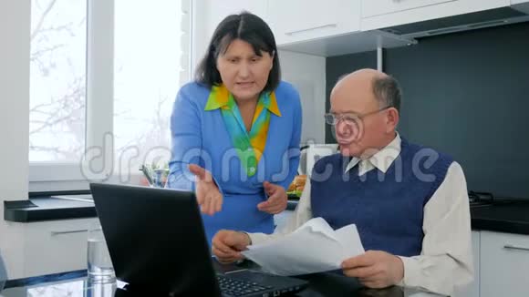 养老金领取者的家庭事务老妇人和丈夫一起发誓坐在手提电脑后面拿着文件视频的预览图