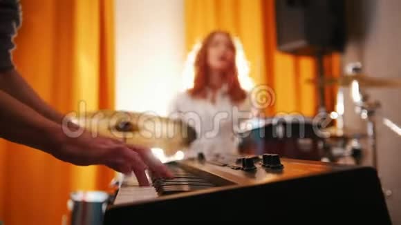 重复很有表现力的女鼓手还有一个键盘手从手到鼓的焦点背光灯视频的预览图