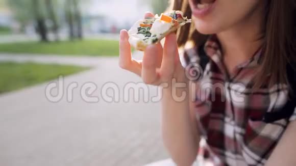 在街上吃美味披萨的女人的细节视频的预览图