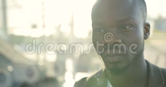 一幅严肃迷人的非洲男人的肖像然后在阳光下照相机4K录像视频的预览图