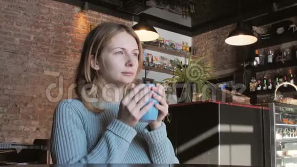 年轻女子在咖啡馆喝咖啡舒适温馨的氛围理念视频的预览图