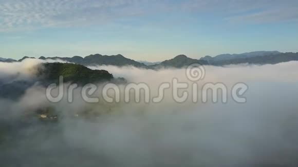 山顶从雾中突出几乎看不见绿色山谷视频的预览图