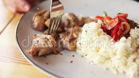 镜头从盘子里的米饭和肉到女人脸一个年轻女人用叉子吃炸肉视频的预览图