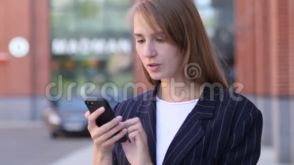 商务女性在办公室外使用手机弥补损失视频的预览图