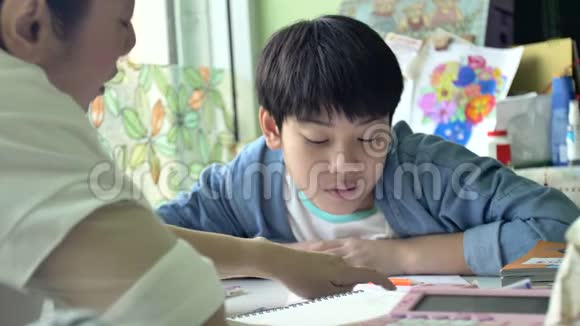 慢动作的快乐亚洲母子做你的家庭作业微笑的脸4K视频的预览图