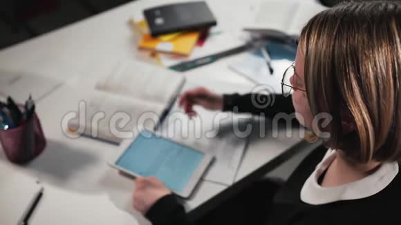 特写女生或学生使用平板电脑并在工作簿中书写她在做作业视频的预览图