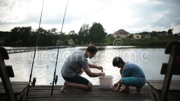 无忧无虑的爸爸和儿子准备在湖上钓鱼视频的预览图