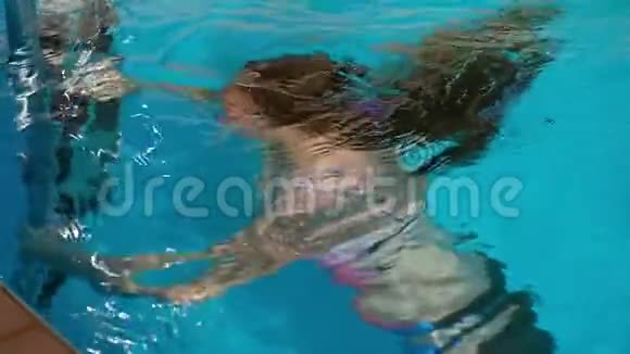 可爱的少女在游泳池水下游泳慢动作视频视频的预览图