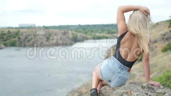 年轻女孩梦想着坐在岩石上视频的预览图