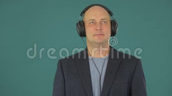 一个穿着西装听着耳机音乐的男人一个人喜欢音乐的声音视频的预览图
