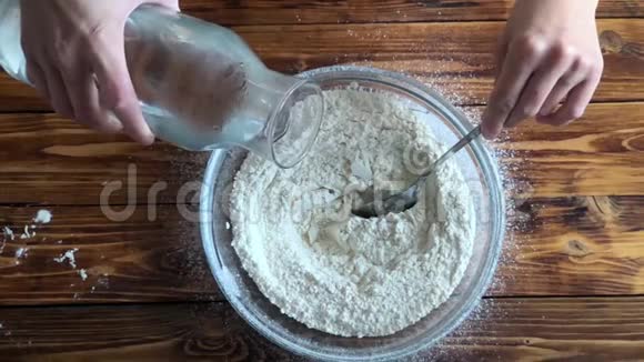 女人在碗里给面粉加水做自制披萨的女人视频的预览图