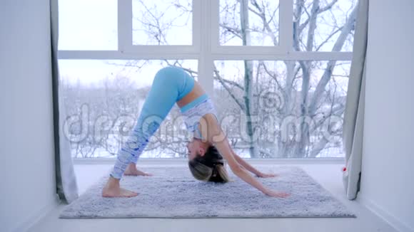 健康的生活方式健身女性在室内练习瑜伽的窗口背景视频的预览图