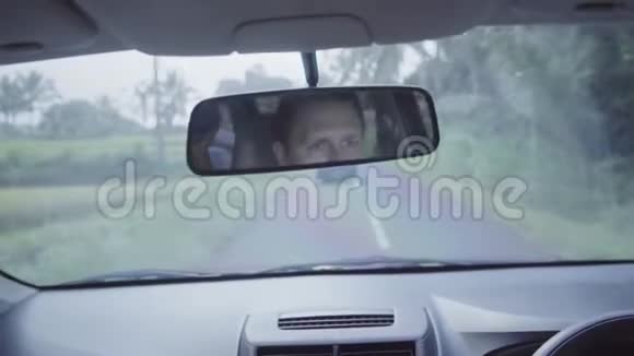 成熟白种人的脸被反射在移动汽车的后视镜上视频的预览图