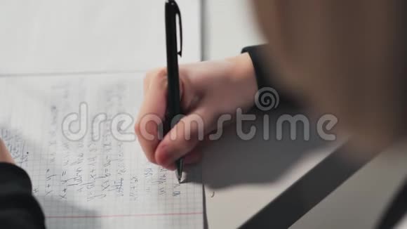 一个女学生在一本作业本中写字她在做作业视频的预览图