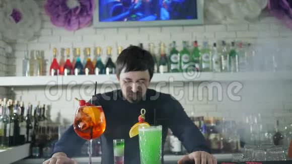 酒保画像旁边生动的酒精饮料与浆果背景酒吧内部与彩色瓶子视频的预览图