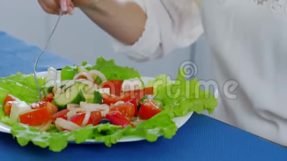 女人从盘子里切碎的新鲜蔬菜中吃有用的食物视频的预览图