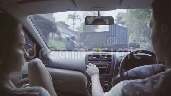 高加索男人和女人坐在车里在农村热带地区的某个地方骑马视频的预览图
