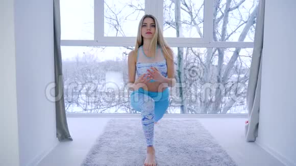 现代运动爱好身材匀称的女性在家附近练习瑜伽视频的预览图